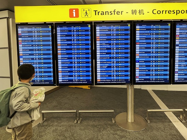 パリの空港で日本行きの乗り継ぎ便を確認する7歳のスイス留学生