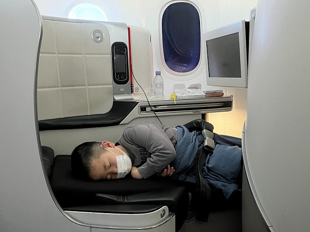 パリ行きの飛行機内で眠る7歳のスイス留学生
